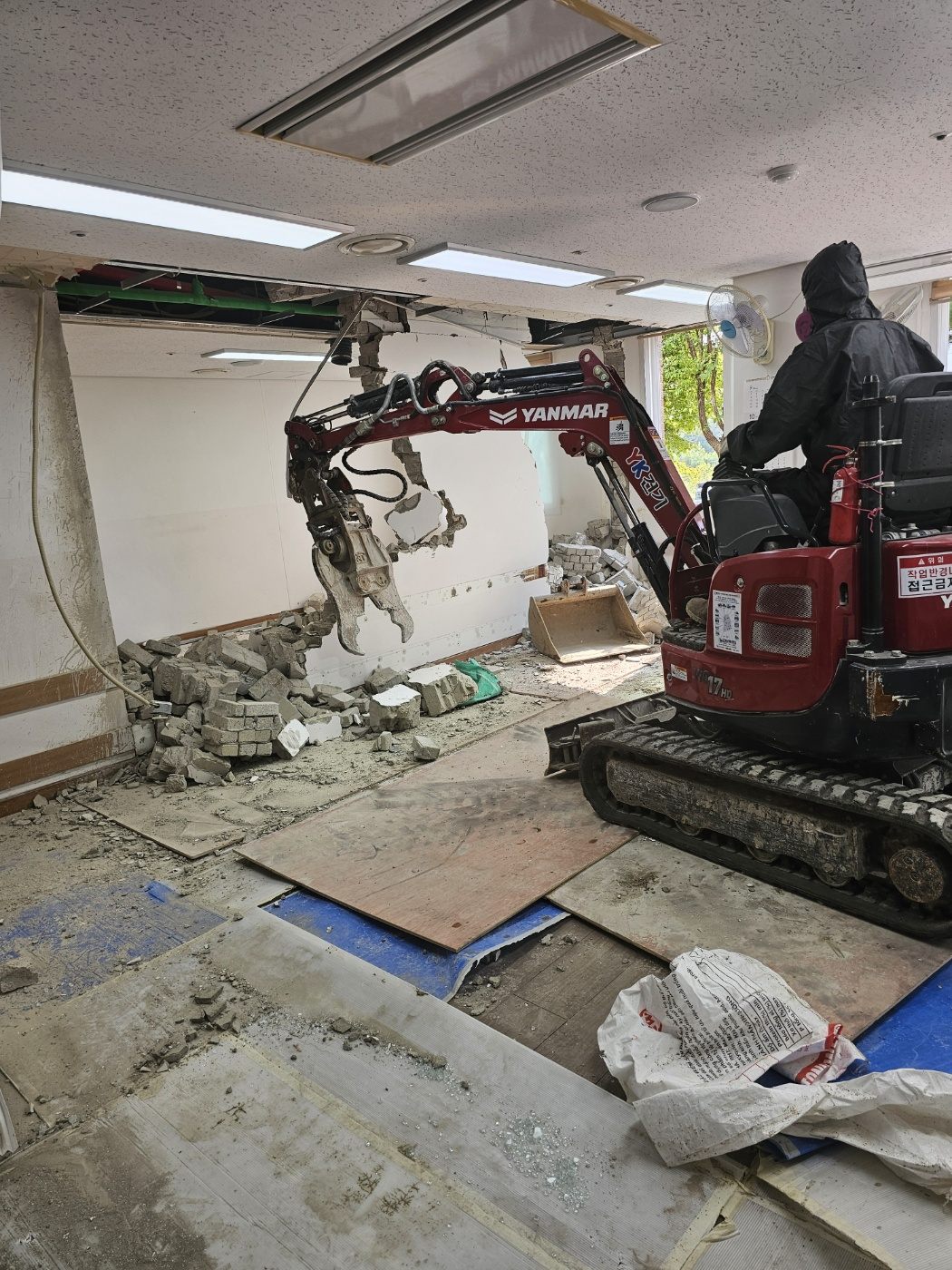 미니 굴착기로 상가 벽체를 철거하는 현장
